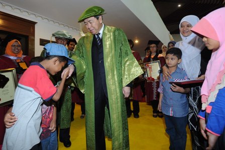 The Sultan presenting the Ph.D scroll to Puan Norasmat Hassan, the widow of the late Hazril Azmin Saari, a graduate who died of cancer 
